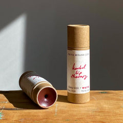 Lip balm tubes in brown cardboard with red text, Priya Means Love brand