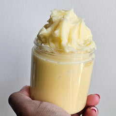 Close-up of golden argan butter with rich, creamy texture in a sleek glass jar