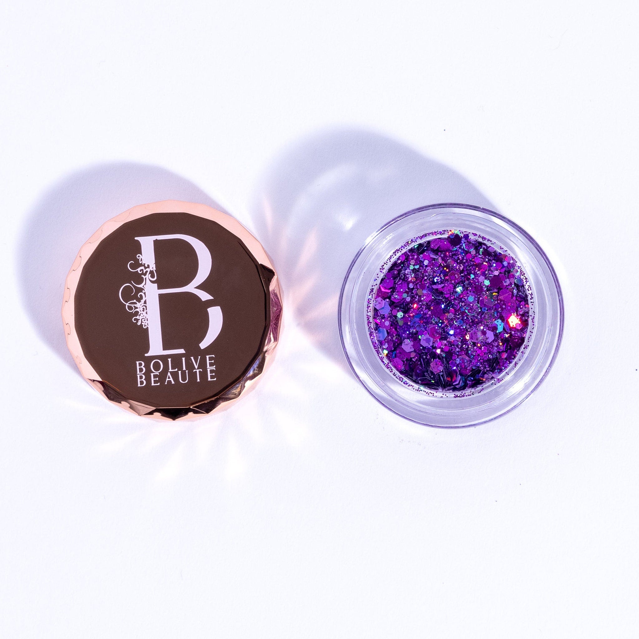 Close-up of deep purple holographic amethyst eyeshadow pan with shimmering multi-color reflections