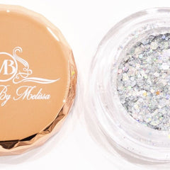 Side angle view of holographic silver glitter eyeshadow pot catching light with prismatic reflections