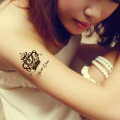 Temporary tattoo with crown design, black ink, cursive text "King and Queen" on arm