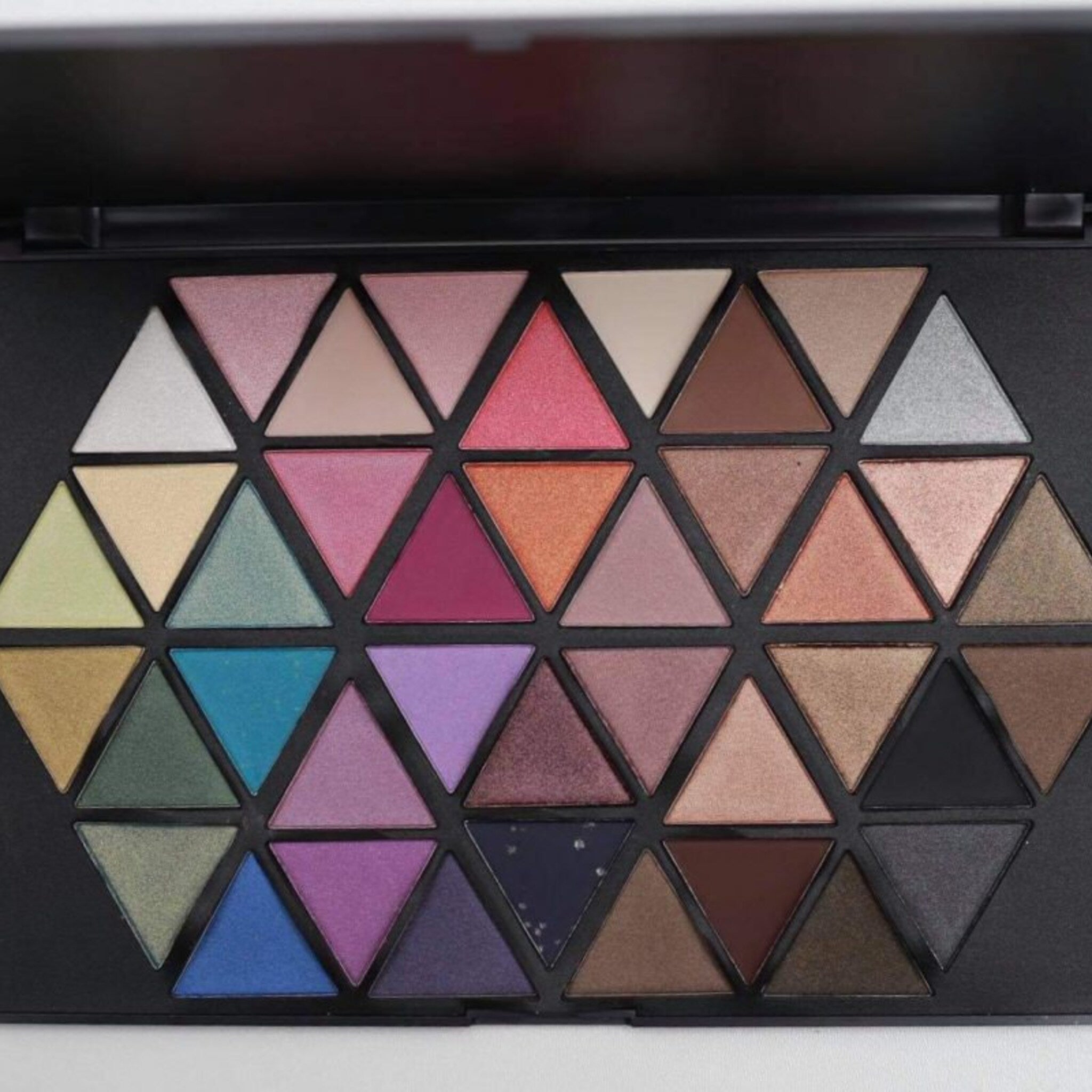 Vivid Cosmetics eyeshadow palette with 12 vibrant matte and shimmer shades in a sleek black compact