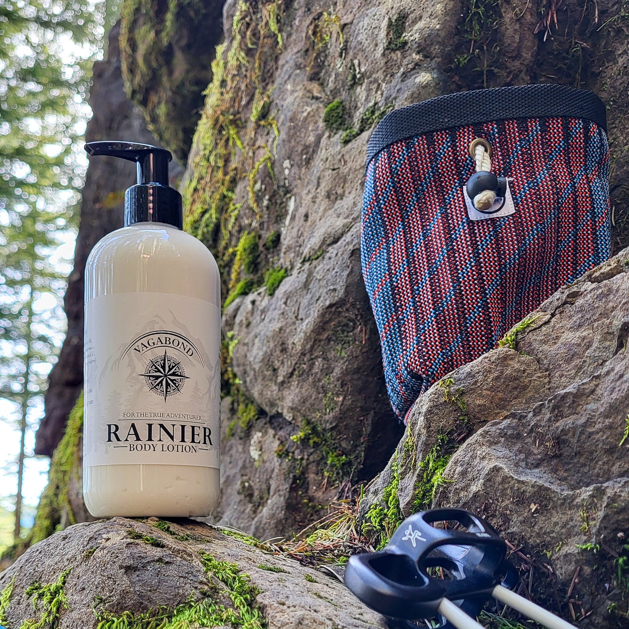 Body lotion bottle with black pump and white label, next to a patterned bag on a rock