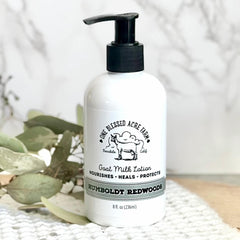Goat milk lotion bottle with black pump, white label, and One Blessed Acre Farm text