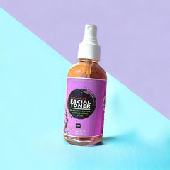 Facial toner bottle with purple label, clear liquid, and white spray top on colorful background