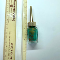 Side view of vintage green eyeliner in glass bottle with golden spire lid, showcasing tapered shape and label details