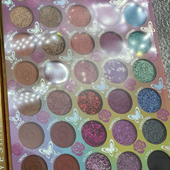 Eyeshadow palette with multiple colors, glitter, and matte finishes for eye makeup application