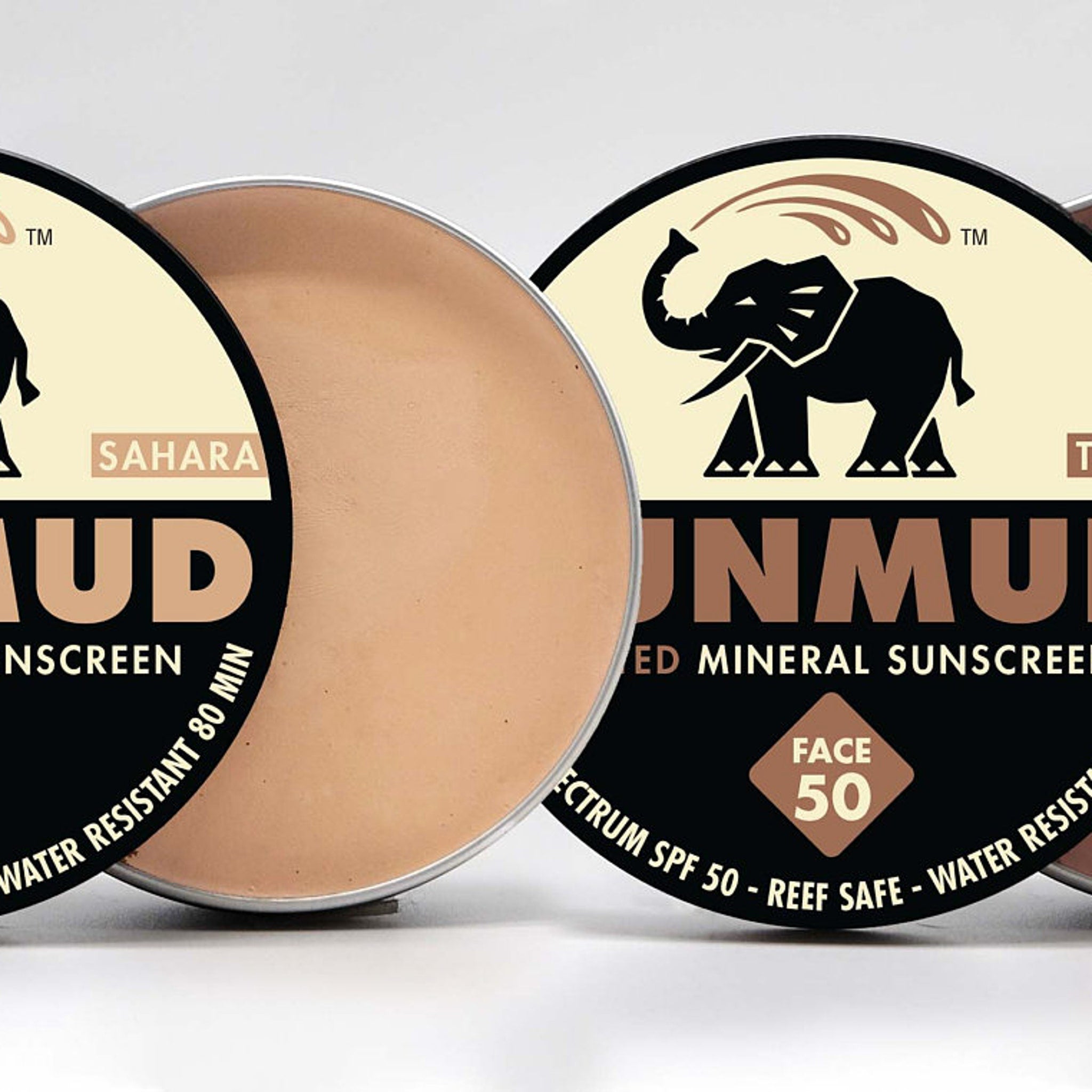 Mineral sunscreen compacts with beige cream, silver rim, and black label with SUNMUD text
