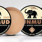 Mineral sunscreen compacts with beige cream, silver rim, and black label with SUNMUD text