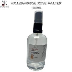 Rose water spray bottle, clear glass, black cap, and "AMAZIGHROSE" label visible