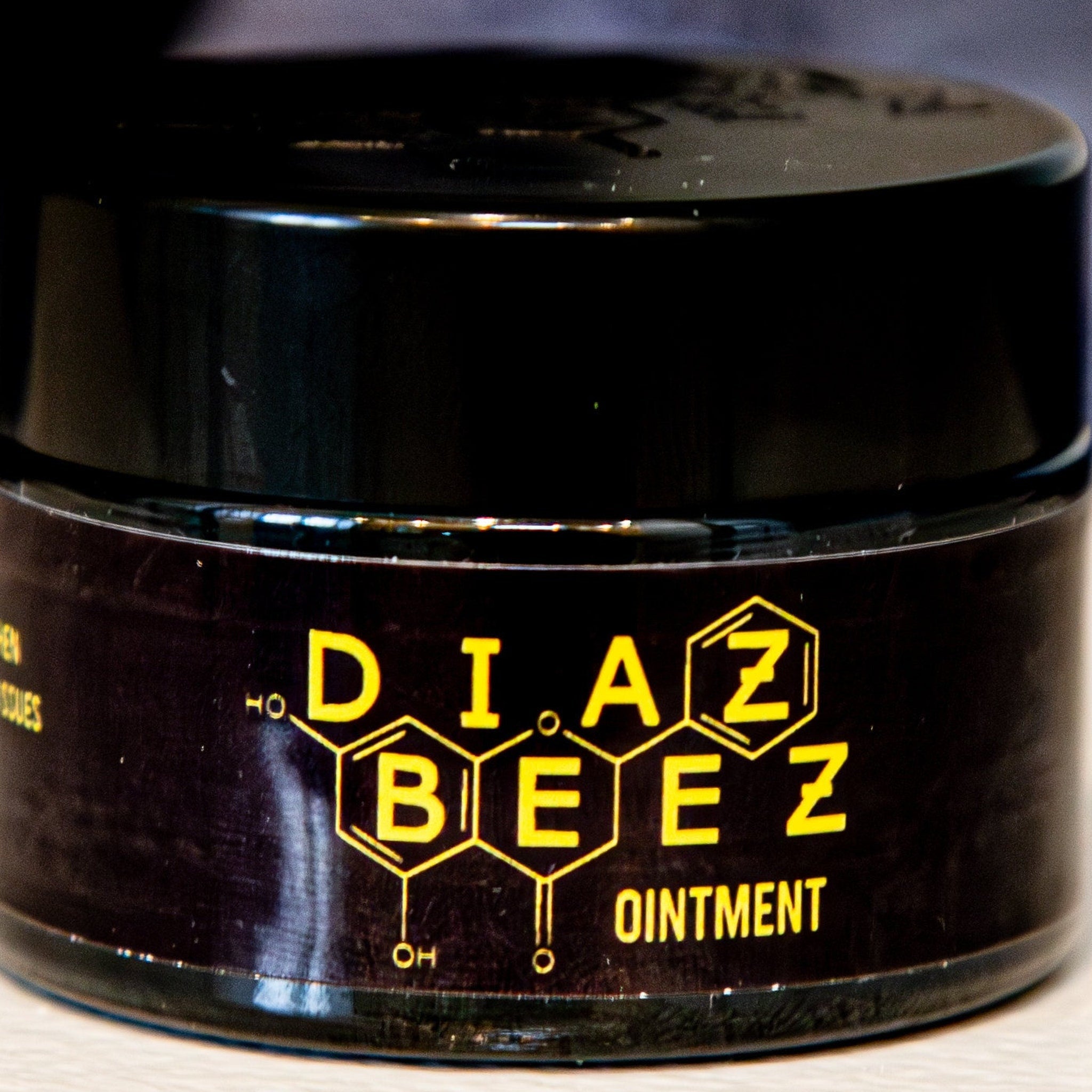 Ointment salve jar with black glass, yellow text, and DiazBeez branding
