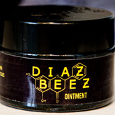 Ointment salve jar with black glass, yellow text, and DiazBeez branding