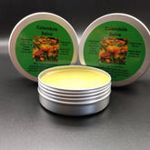 Calendula salve in metal tins with yellow salve and green labels, Bumbling Acres Farm