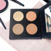 Eye shadow quad with four circular shades, black glitter palette, and mirror
