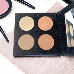 Eye shadow quad with four circular shades, black glitter palette, and mirror
