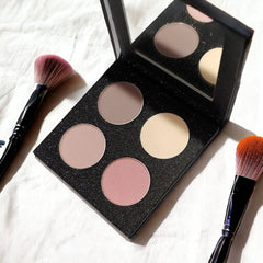 Hand applying shimmery vanilla rose eyeshadow with a blending brush onto eyelid