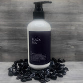 Body lotion bottle with black pump, white bottle, and black label, Elysian Blends brand name visible