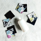 Makeup remover pads, floral pattern fabric, black backing, on white surface