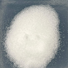 White granular substance on dark blue surface, close up view