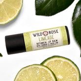 Lip balm with Wild Rose label, black tube, and lime slices on white background