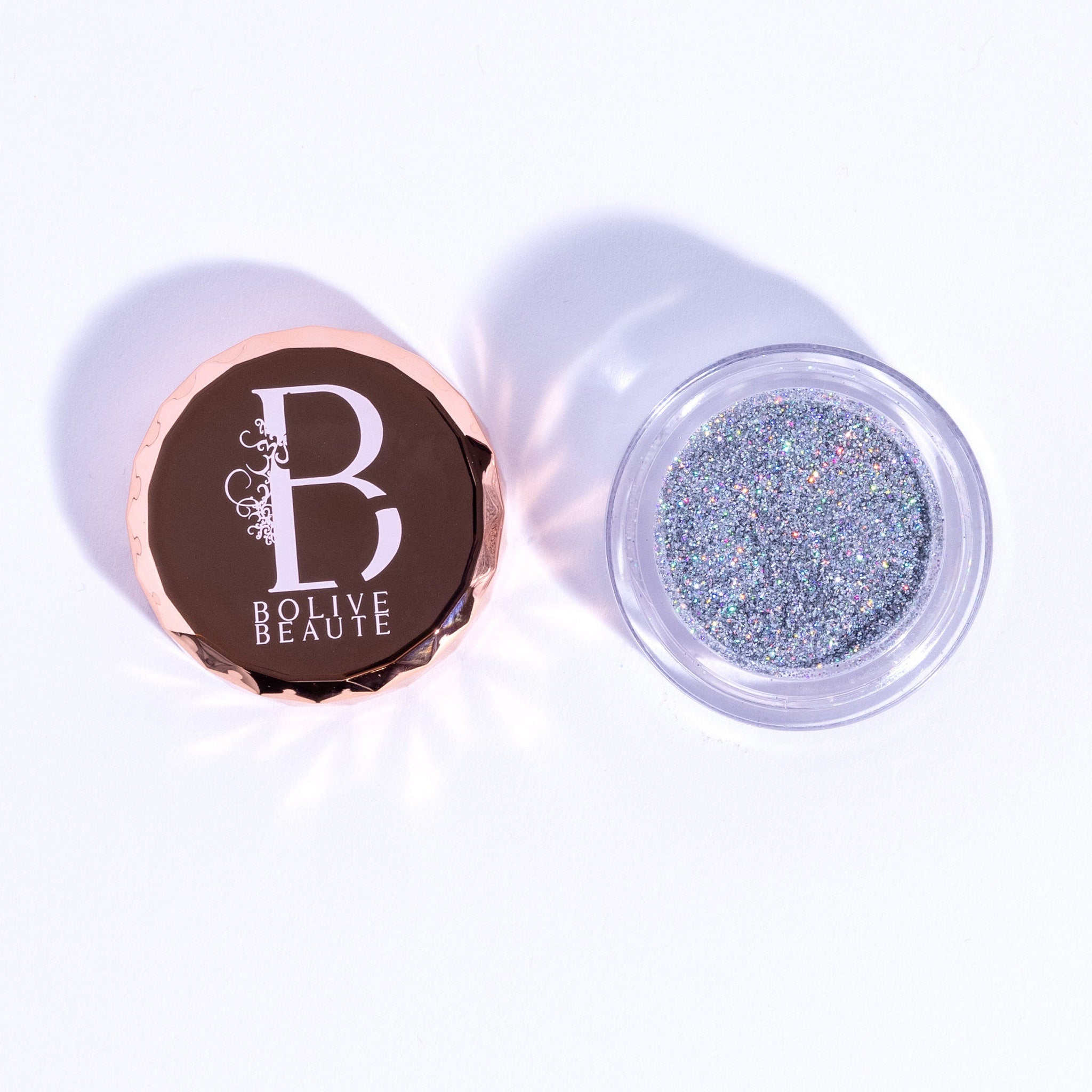 Close-up of holographic silver glitter eyeshadow in compact with reflective shimmer particles