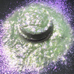 Close-up of iridescent loose pigment shifting from white to purple with ultraviolet shimmer