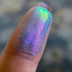 Extreme close-up of multichrome unicorn tracks eyeshadow showing shifting iridescent hues from purple to teal