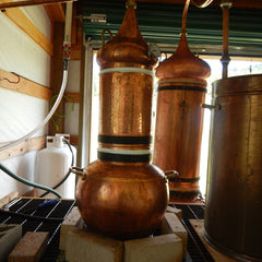 Copper still with copper and black bands, used for distilling liquids