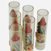 Eye shadow crayons with pink color, clear plastic tubes, and Revlon brand text visible