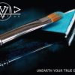 Paintbrush with silver handle, orange bristles, and blue surface against dark background with logo