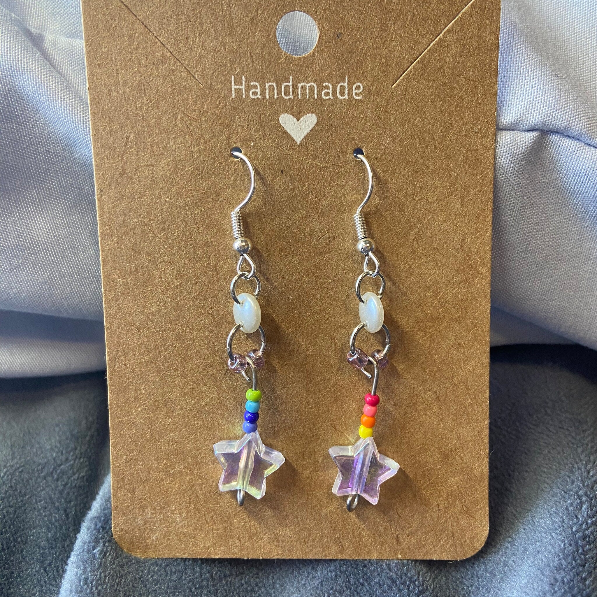 Colorful Stars Dangle Eye Shadow palette with vibrant shades in a sleek black compact featuring star-shaped charms