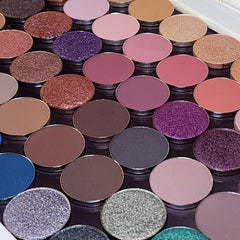 Side view of 54-pan eyeshadow palette showing matte, shimmer, and pressed pigment squares in rainbow colors