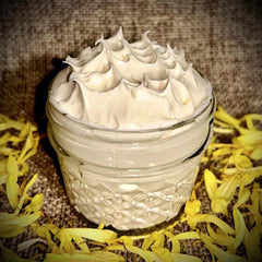Cream jar with white cream, glass jar, and yellow flower petals around it.