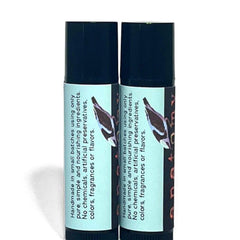 Lip balm tubes with black caps and light blue labels with text, side view