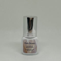 Lash adhesive bottle with silver cap, white label, and Halo Beauty text