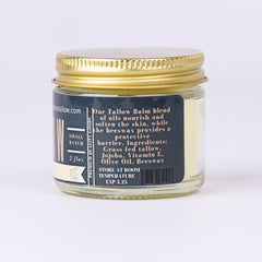 Tallow balm jar with gold lid, glass container, and product label with text