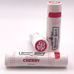 Lip balm tubes in white and red with Bonbon Balm branding and text "Basic Cherry