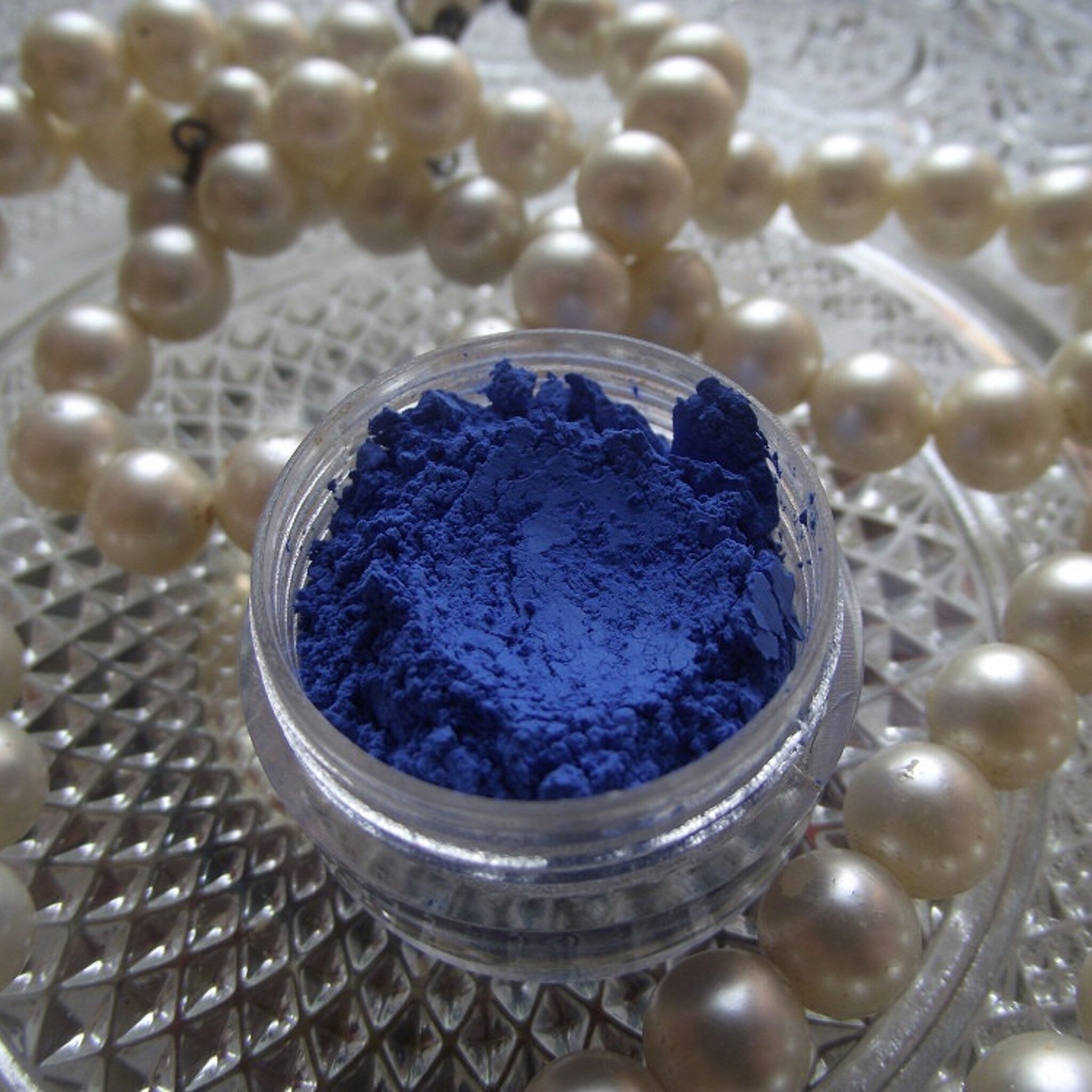 Close-up of Pop Blue Sapphire matte eyeshadow pan with vibrant deep blue powder in round compact