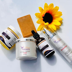 Skin care products with white, black, and gold labels, Mona Venus brand, with a yellow flower
