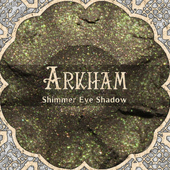 Shimmer eye shadow with amber brown and green sparkle, ARKHAM brand name visible