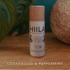Lip balm tube with HIILA label, brown and beige, on wooden surface