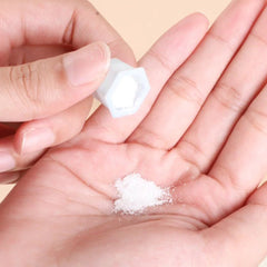 White powder being poured from a blue container into a hand, close-up shot