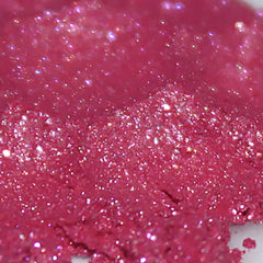Side view of vegan loose powder eye shadow in bright hot pink with sparkling shimmer particles