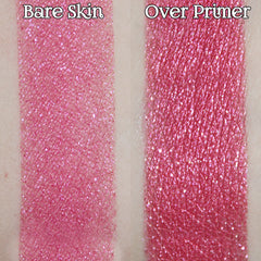 Hand applying vibrant hot pink sparkle loose powder eyeshadow with fingertip for bold makeup look