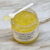 Gel to milk cleansing balm in yellow, clear jar with white spoon, Botanic Glow label visible