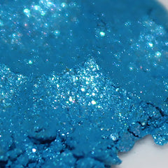 Blue glitter powder with sparkling texture and visible light reflection