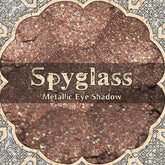 Metallic rose brown loose powder eye shadow in a small round jar with steampunk-inspired label