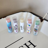 Lip balm tubes with clear caps, colorful labels, and BEEzy & Birch text on white surface