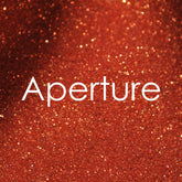 Small glass jar with gold sifter lid containing vibrant glitter eye shadow in assorted colors