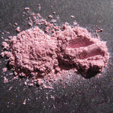 Loose pigment eyeshadow, pink lavender powder with shimmer on dark surface